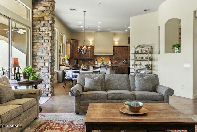 tiled living room featuring ceiling fan with notable chandelier