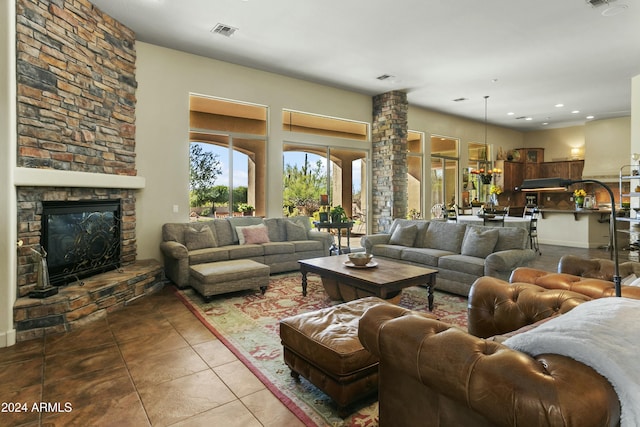 living room with a fireplace, decorative columns, and tile patterned floors