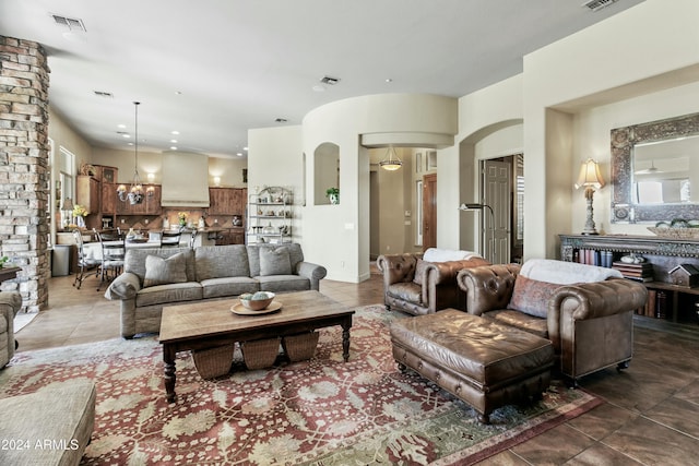 tiled living room with a notable chandelier