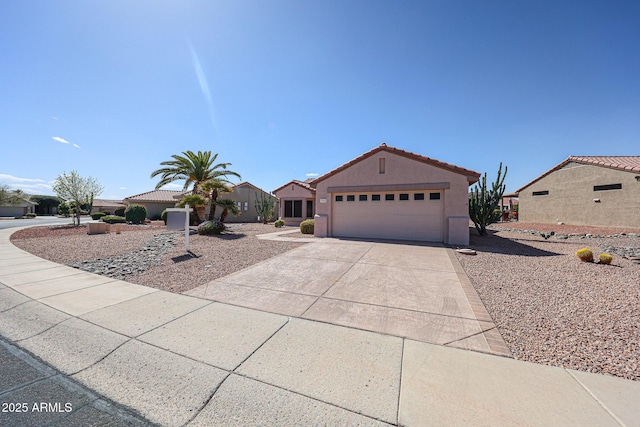 view of front of house with driveway, a tile roof, a garage, and stucco siding