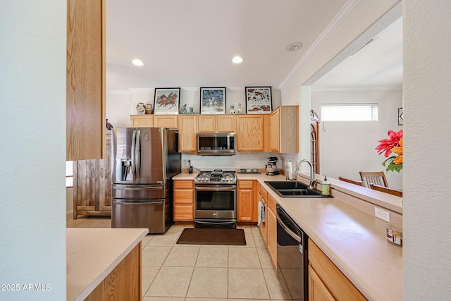 kitchen featuring light tile patterned floors, light countertops, light brown cabinetry, appliances with stainless steel finishes, and a sink