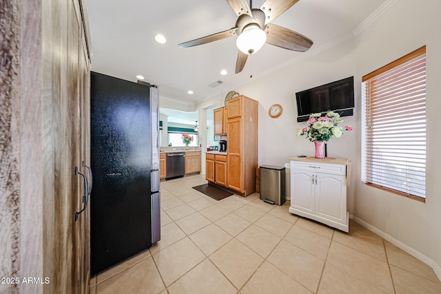 kitchen with light countertops, appliances with stainless steel finishes, light tile patterned flooring, and crown molding