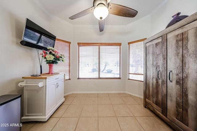 interior space with light tile patterned floors, baseboards, and crown molding