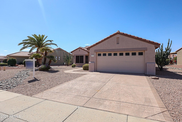 view of front of home featuring a garage, concrete driveway, a tile roof, and stucco siding