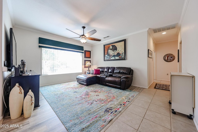 living area with ornamental molding, visible vents, and a ceiling fan