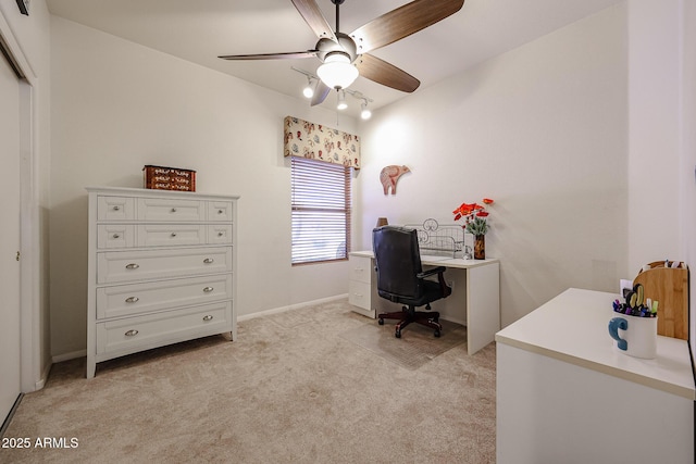 office space featuring baseboards, a ceiling fan, and light colored carpet