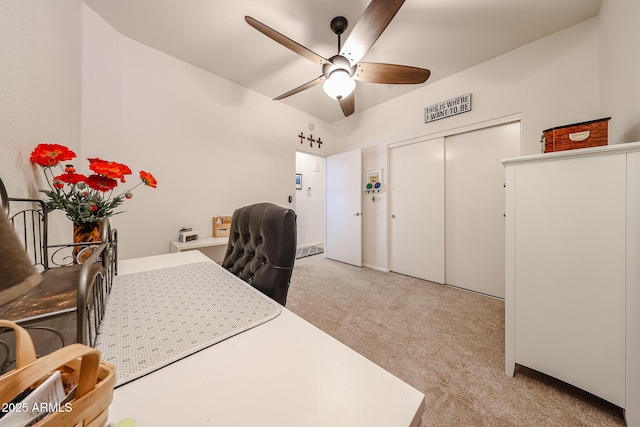 carpeted office space with a ceiling fan