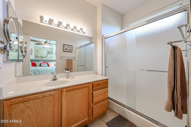 bathroom with ceiling fan, a shower stall, ensuite bath, vanity, and tile patterned flooring