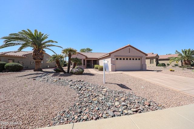 mediterranean / spanish-style house with driveway, an attached garage, a tile roof, and stucco siding