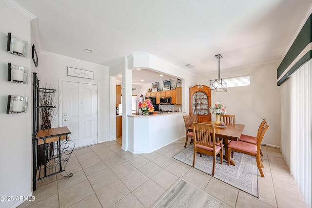 dining area featuring light tile patterned floors and crown molding