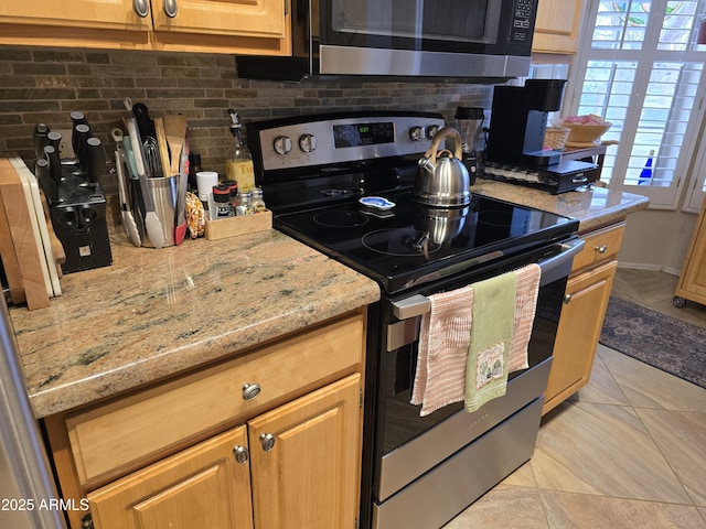 kitchen featuring stainless steel range with electric stovetop, tasteful backsplash, light stone countertops, and light tile patterned flooring