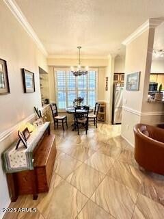 living room with ornamental molding and an inviting chandelier