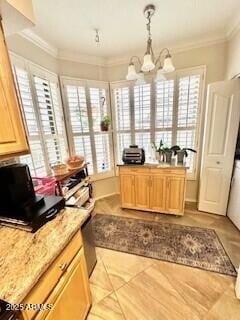 kitchen featuring decorative light fixtures, ornamental molding, a healthy amount of sunlight, and light brown cabinets