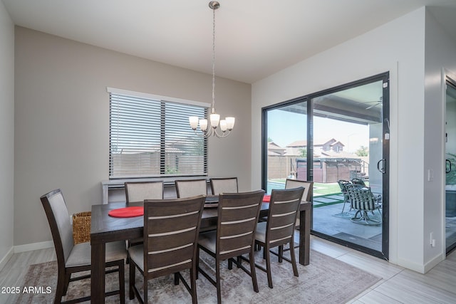 dining area featuring a notable chandelier and baseboards