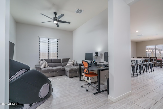 office space featuring light tile patterned floors, visible vents, ceiling fan with notable chandelier, and baseboards