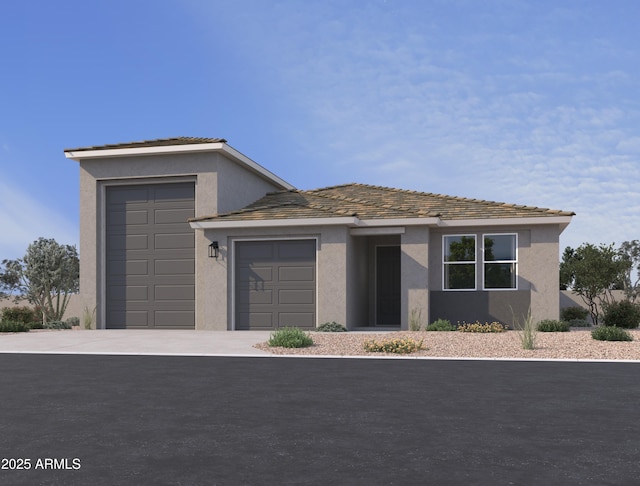 view of front of home with an attached garage, concrete driveway, and stucco siding