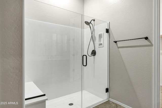 full bath featuring a textured wall and a stall shower