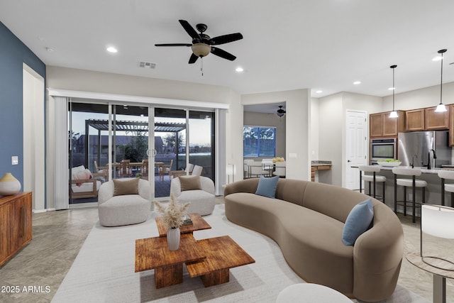 living room featuring ceiling fan, visible vents, and recessed lighting