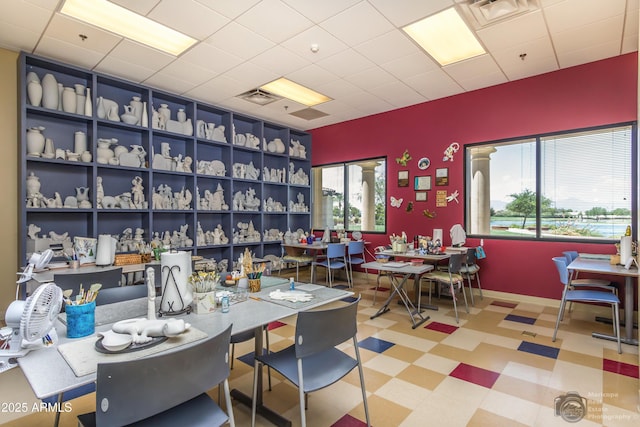 dining space with baseboards, a drop ceiling, visible vents, and tile patterned floors