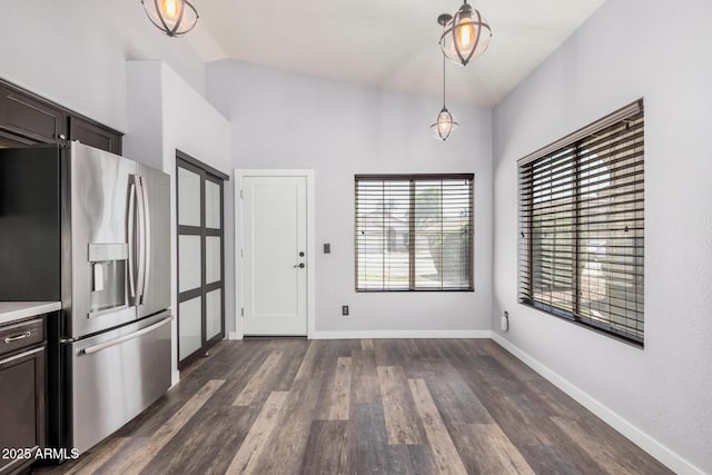 kitchen with dark brown cabinetry, stainless steel refrigerator with ice dispenser, light countertops, dark wood-type flooring, and decorative light fixtures