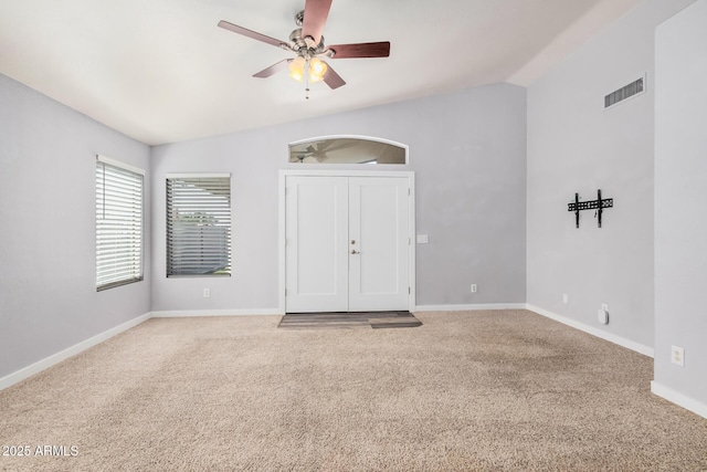 carpeted spare room featuring visible vents, a ceiling fan, baseboards, and lofted ceiling