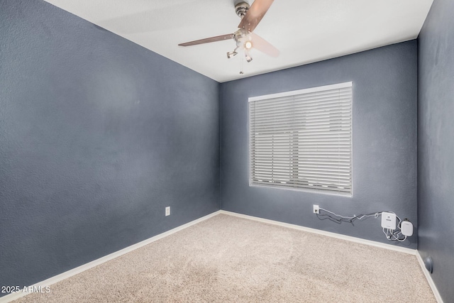 spare room with baseboards, carpet flooring, and ceiling fan
