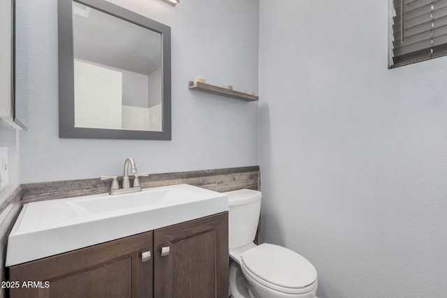 bathroom featuring vanity and toilet