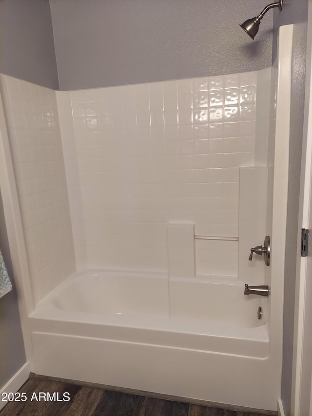 full bath with baseboards, shower / bathing tub combination, and wood finished floors