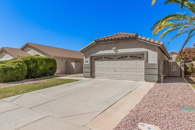 mediterranean / spanish home with a garage, stucco siding, a gate, concrete driveway, and a tile roof