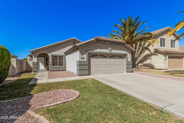 mediterranean / spanish home featuring a front lawn, stucco siding, concrete driveway, an attached garage, and a tile roof