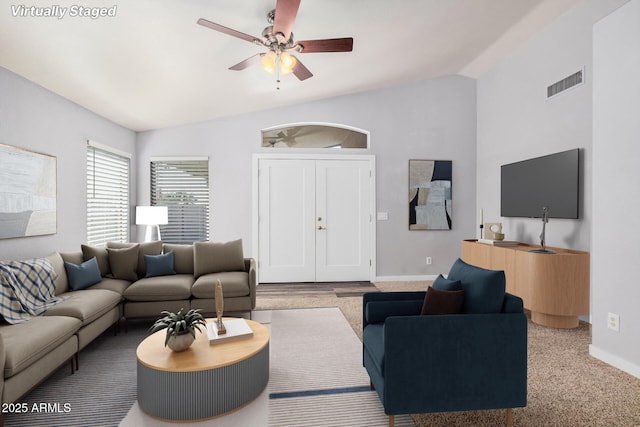 living area featuring visible vents, baseboards, ceiling fan, and vaulted ceiling
