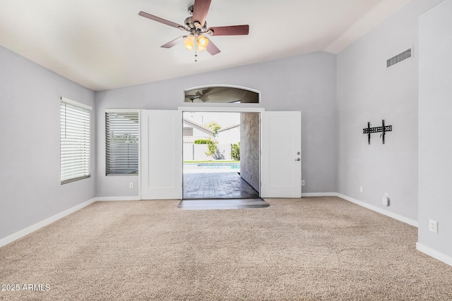 carpeted spare room with baseboards, visible vents, a ceiling fan, and lofted ceiling