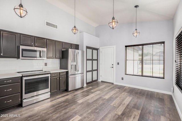 kitchen with visible vents, high vaulted ceiling, tasteful backsplash, dark wood finished floors, and appliances with stainless steel finishes