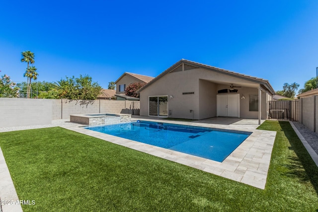 view of swimming pool with a pool with connected hot tub, a fenced backyard, a patio area, a ceiling fan, and a yard