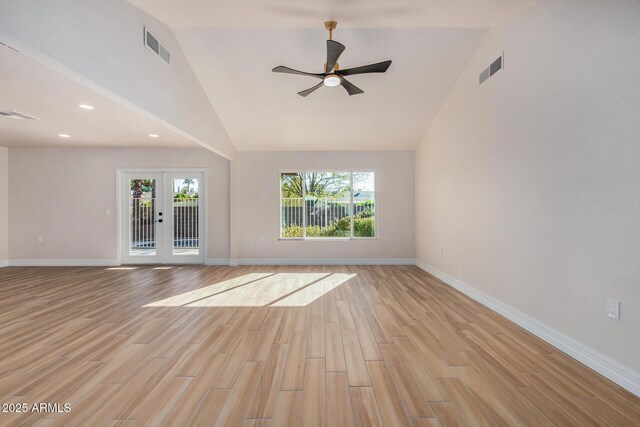 unfurnished living room featuring light hardwood / wood-style floors, ceiling fan, french doors, and high vaulted ceiling