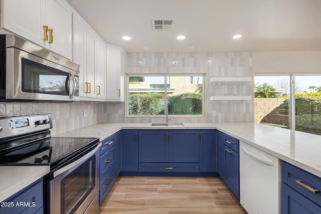 kitchen with sink, white cabinetry, tasteful backsplash, light stone countertops, and appliances with stainless steel finishes