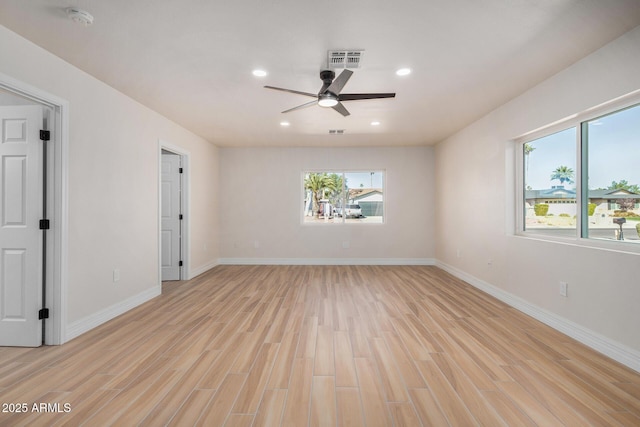 empty room featuring ceiling fan, light hardwood / wood-style flooring, and a healthy amount of sunlight