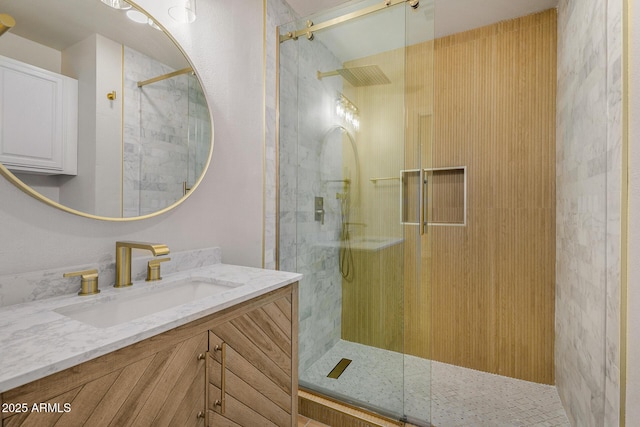 bathroom featuring a shower with door and vanity