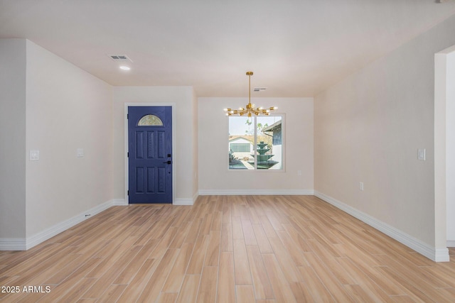 entryway featuring an inviting chandelier and light hardwood / wood-style floors