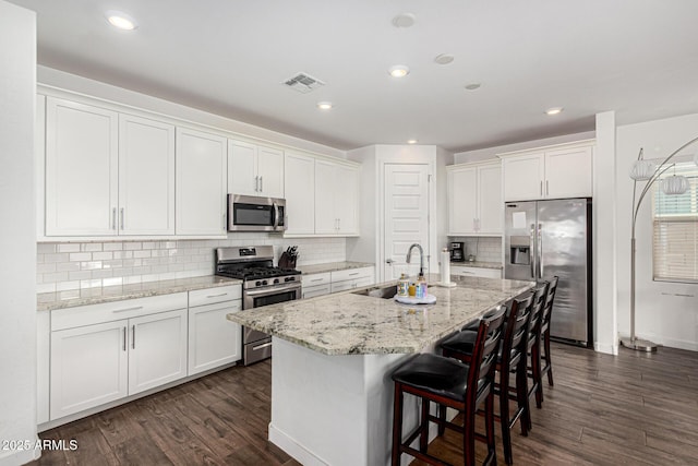 kitchen with visible vents, white cabinetry, stainless steel appliances, and dark wood-type flooring