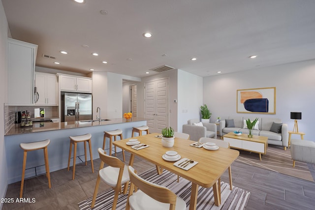 dining room featuring sink and dark wood-type flooring