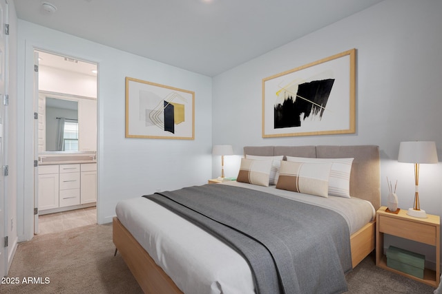 bedroom featuring connected bathroom and light colored carpet