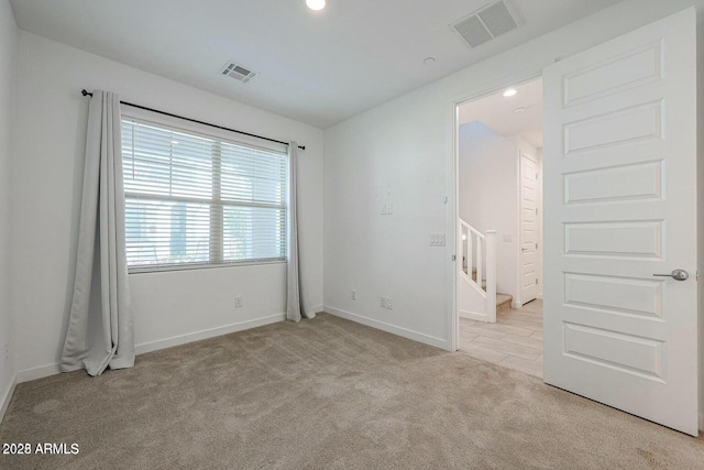 unfurnished room featuring light carpet