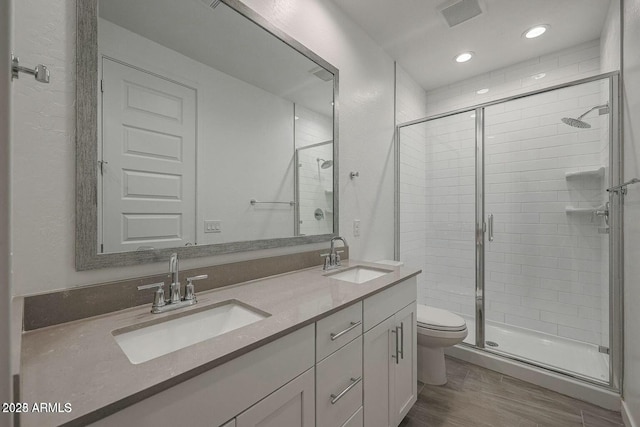 bathroom with walk in shower, wood-type flooring, toilet, and vanity