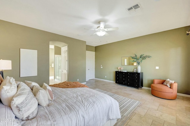 3531 E Norwood Cir, Mesa, AZ 85213 - bedroom with arched walkways, baseboards, stone tile flooring, ceiling fan, and ensuite bath