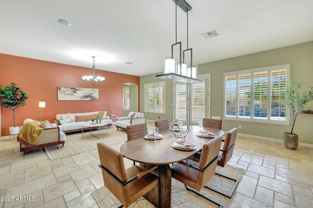 3531 E Norwood Cir, Mesa, AZ 85213 - dining space featuring stone tile floors, a chandelier, baseboards, and an accent wall