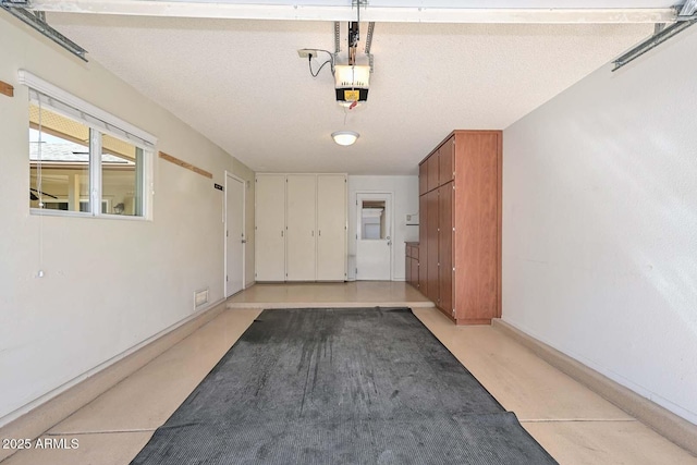 garage with baseboards and a garage door opener