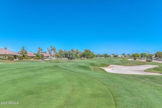 view of home's community with view of golf course and a yard