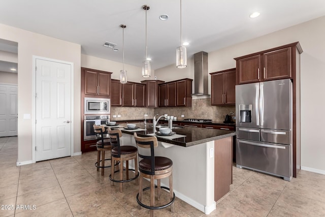 kitchen featuring wall chimney exhaust hood, visible vents, appliances with stainless steel finishes, and decorative backsplash