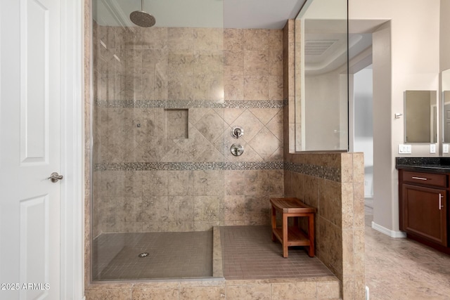 bathroom featuring tile patterned flooring, vanity, and a walk in shower